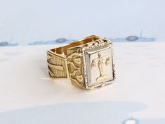 a gold ring with an image of the cross on it