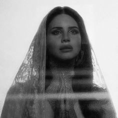 a black and white photo of a woman with long hair wearing a veil over her head