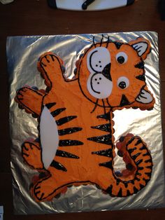 a cake shaped like a tiger sitting on top of a piece of tin foil