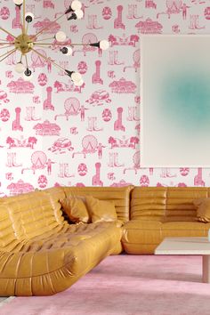 a living room with pink and white wallpaper, leather couches and coffee table