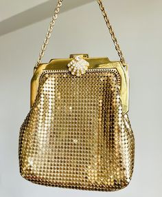 "A very lovely and delicate vintage Whiting and Davis gold metal little purse.  Gold tone metal body, a gold chain and a gorgeous clasp with rhinestones makes this little purse a great accessory.  This bag is lined with golden satin.  Both bag and lining in great vintage condition.  The clasp is in great condition and all the stones are intact.  A great accessory for a special event or a bride.  Measurements With - 4\" Height - 4 1/2 Drop - 3 1/2 My store strives for excellence, honesty and transparency.  Please ask questions and/or request additional photos, if needed, before making a purchase.     Please note: *Every item in my store is vintage used, unless stated in the description otherwise.     *My store does not accept returns.   *My store does not issue refunds, unless an item has n Chic Gold Metal Evening Bag, Gold Metal Bag For Party, Gold Metal Party Bag, Elegant Metal Bags With Gold-tone Hardware, Gold Metal Evening Bag For Parties, Gold Clutch Evening Bag With Chain Strap, Elegant Gold Evening Bag With Chain, Vintage Gold Bag With Chain Strap, Vintage Gold Bags With Chain Strap