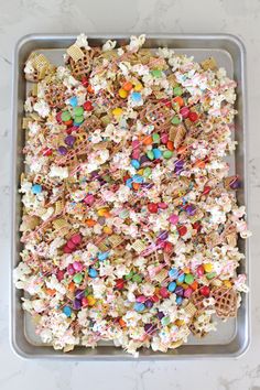 a tray filled with lots of different types of candy and cereal on top of a table