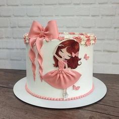 a white and pink cake with a girl on it