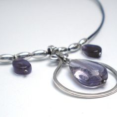 Sterling silver, amethyst teardrops and sterling melon beads combine in this lyrical necklace. A subtle combination of textures draws the eye; your throat becomes the center of attention...  Center pendant is approx. 1.5" long. Strung on a supple black leather cord, about 14" long, plus a 2" sterling chain extender. Hand-formed sterling hook closure.  Amethyst is the birthstone for February. Amethysts are commonly believed to hold powers over dreams, peace, healing, love, courage, spiritual uplifting, and a general overall happiness. And who can resist that luscious purple color? Modern Nickel-free Teardrop Pendant Jewelry, Silver Dangle Necklace With Polished Beads, Silver Dangle Necklaces With Polished Beads, Silver Necklace With Polished Beads, Silver Adjustable Drop Necklaces, Faceted Lavender Teardrop Jewelry, Modern Dangle Drop Necklace As Gift, Adjustable Teardrop Metal Drop Necklace, Modern Dangle Drop Necklace For Gifts