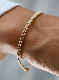 Our double wrap bracelet is one of our number one best selling bracelets! The petite double wrap beaded bracelet is made up of 2mm beads and can be worn as a bracelet or a single layer choker necklace! Also available in Silver. Details: - Gold filled 2mm beads - Gold filled lobster clasp and end chain - 13" with 2" extender SKU: B1116 Materials + Care Gold Bracelets With Tiny Beads For Layering, 14k Gold Filled Bracelets For Layering, Gold Wrap Bracelet With Tiny Beads As A Gift, Gold Adjustable Double Strand Beaded Bracelets, Minimalist Single Strand Gold Bracelet, Gold Bracelets With Round Beads For Layering, Gold Wrap Bracelet For Layering, Gold Double Strand Beaded Bracelet For Gift, Gold Double Strand Beaded Bracelet Gift