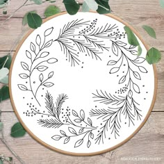 a embroidery hoop with leaves and berries on it