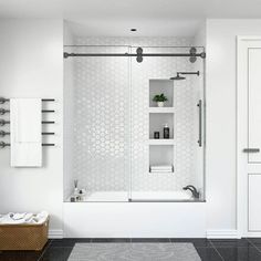 a white bathroom with black tile flooring and wall mounted shelving above the shower