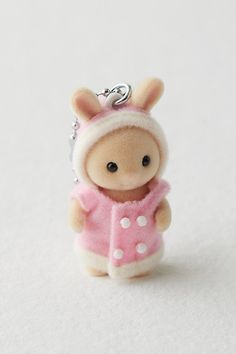 a small keychain with a little animal wearing a pink dress