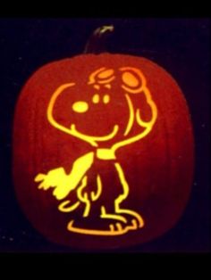 a pumpkin carved to look like a cartoon character with a dog on it's face