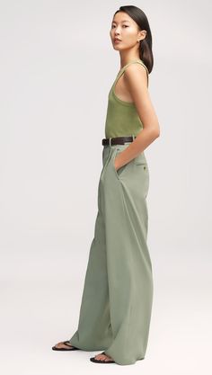 Our slouchy Pleated Trouser is a timeless piece that finds balance in touting both a wide-leg and a slim fit. The pant borrows from traditional suiting with a curtained waistband — which sits at the natural waistline for a flattering appearance — alongside pleated detailing. Silk Pants Outfit, Green Trousers Outfit, Tailored Pants Outfit, Womens Wool Pants, Blazer Details, Denim Vests, Green Trousers, Soft Classic, Work Wear Women