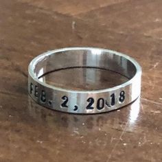 Sterling silver stackable name ring personalized with a name or milestone date- graduation ring, anniversary band, mom or dad ring to cherish a lifetime. - Sterling silver hand stamped ring measures 4mm. - Personalize with up to 12 characters. - Unisex band available in sizes: 5, 6, 7, 8, 9, 10, 11, 12,13,14 They will stretch slightly when stamped, so more letters = more stretching. --------------------------------------- HOW TO ORDER: 1. Select Your Drop Downs. 2. Add to cart. 3. Leave me a not Dad Ring, Date Ring, Stackable Name Rings, Graduation Ring, Mother's Ring, Ring Name, Graduation Rings, Stamped Ring, Hand Stamped Ring