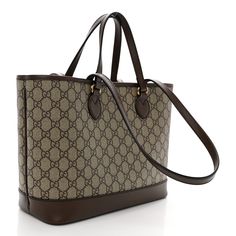 This is an authentic GUCCI GG Supreme Monogram Textured Calfskin Medium Ophidia Shoulder Tote Bag in Beige, Ebony, and New Acero. This bag features an antiqued aged gold GG logo on the front. The top opens to a beige interior. The bag has two different straps allowing it to be carried by hand or over the shoulder. Beige Interior, Gg Logo, Shoulder Tote Bag, Shoulder Tote, Calf Skin, Monogram, Gucci, Tote Bag, Texture