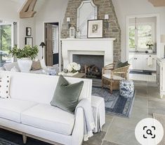 a living room filled with furniture and a fire place in the middle of a room