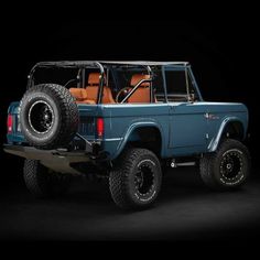 an old blue truck is parked in the dark with its doors open and four wheel drive