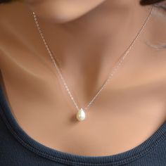 "You can't go wrong with the classic pearl drop necklace. This simple teardrop design will go with everything and is pretty enough for special occasions as well. A creamy white, genuine teardrop pearl slides freely along sterling silver chain in this floating pearl necklace. This lovely pearl is a full drop shape and measures approx. 13mm tall x 9mm wide. Tiny white pearls connect the sterling silver lobster clasp. Simply elegant, and perfect for the bride who wants a minimalist, classic piece o Pearl Teardrop Drop Necklace As Gift, Minimalist Teardrop Pearl Chain Drop Necklace, Pear-shaped Drop Necklace With Pearl Chain For Gift, Teardrop Pearl Charm Necklace, Classic Pearl Drop Necklace Gift, Pearl Drop Teardrop Pendant As Gift, Pearl Drop Necklace As Gift, Classic Pearl Drop Necklace As A Gift, Classic Pearl Drop Necklace For Gifts