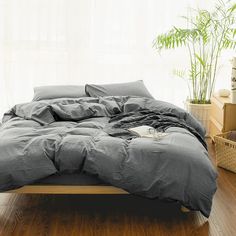 an unmade bed sitting on top of a wooden floor