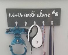 there is a sign that says never walk alone and some leashes are hanging on the wall