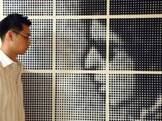 a man standing in front of a wall with dots on it