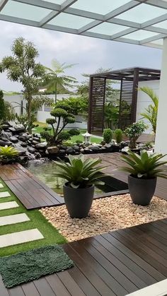 an outdoor area with plants and rocks in the center, along with a water feature