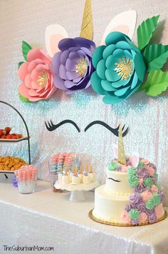 a table topped with cakes and desserts covered in paper flowers