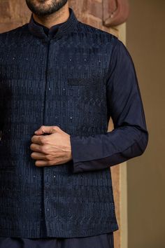 Editor's Note Featuring A Navy Blue Viscose Silk Kurta And Churidar With Raw Silk Jacket All Over Embroidered In Resham, Crystal And Beadwork Color: Navy Blue Fabric: Bundi: Raw Silk, Kurta And Churidar: Viscose Silk Component: Bundi, Kurta And Churidar Embroidery Details: Resham, Crystal And Beadwork Care: Dry Clean Only About the Designer Nitika Gujral’s journey with designing clothes started almost four decades back while she was still in high school and held her first exhibition for family a Traditional Blue Nehru Jacket With Intricate Embroidery, Blue Chikankari Embroidered Nehru Jacket For Reception, Designer Embroidered Indigo Traditional Wear, Indigo Embroidered Traditional Wear For Designer Occasions, Diwali Blue Nehru Jacket With Intricate Embroidery, Blue Nehru Jacket With Intricate Embroidery For Diwali, Festive Indigo Sets With Chikankari Embroidery, Indigo Traditional Wear With Zari Work Long Sleeve, Fitted Indigo Kurta With Resham Embroidery