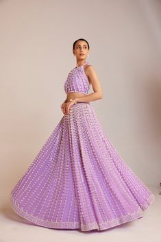 Lilac chandelier pearl skirt paired with halter neck pearl drop crop top skirt set.From Vvani Vats Jhoomar collection.DELIVERY TIMEPlease allow 8-12 weeks for your outfit to arrive.FABRIC DETAILSBlouse - Georgette, Lehenga - Georgette, Lining - Silk BlendProfessional cleaning only. DISCLAIMERHanging tassel at the back are not included in the outfit. Lavender Fitted Choli For Party, Fitted Lavender Choli For Party, Elegant Party Lehenga With Flared Skirt, Festive Party Sets With Flared Skirt, Embellished Long Skirt Set For Party, Elegant Embellished Skirt Set For Reception, Elegant Long Skirt Set For Festive Occasions, Embellished Party Set With Long Skirt, Floor-length Lavender Lehenga For Party