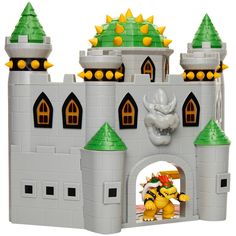 a toy castle with two yellow and green figures on it's front entrance, next to a white background