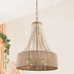 a chandelier hanging from the ceiling in a room with white walls and wood furniture