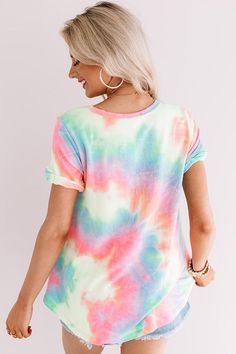 Steal the show with our vibrant "Mai Tai Time" tee featuring soft lightweight material patterned with neon pink, blue, yellow, and green tie dye, a scooped neckline that can be worn off one shoulder, short loose sleeves with tolled cuffs, an accent chest pocket, and a relaxed silhouette that falls into a rounded hemline that can be knotted! We have styled this summer cutie with some distressed denim shorts and trendy sneakers, but you can also wear it with some white flares, clear sandals, and a Summer Multicolor T-shirt With Rainbow Print, Summer Tie Dye T-shirt With Rainbow Print, Tie Dye Short Sleeve Top For Summer, Multicolor Rainbow Print T-shirt For Summer, Trendy Rainbow Print T-shirt For Summer, Trendy Rainbow T-shirt For Summer, Trendy Rainbow Summer T-shirt, Colorful Crew Neck Top For Summer, Colorful Crew Neck Summer Tops