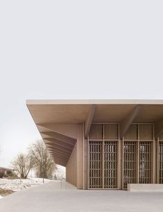 the entrance to an empty building with large doors on it's sides and snow covered ground