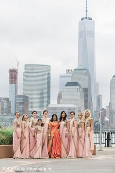 a group of women standing next to each other in front of a cityscape