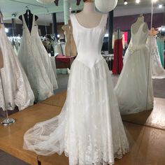 wedding gowns on display in a bridal shop with mannequins behind them