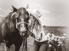 black and white photograph of a woman leaning on a horse