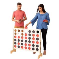 a man and woman standing next to a giant connect board game on an isolated white background