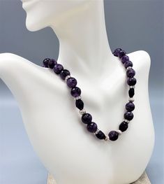 This beautiful choker-style necklace has genuine dark amethyst round and oblong faceted beads. Vintage small Swarovski and sterling silver beads are strategically placed to add shimmer.    I string each bead individually on professional quality silver-plated beading wire for a soft drape. All finishing components are sterling silver filled. The silver-plated lobster claw clasp is tarnish-resistant and very easy to manipulate. You will see expert workmanship in the finishing connections.  Length: 16 1/2 inches with the clasp.  The necklace can be custom ordered in different lengths but please allow extra time for design and shipping. Final price is dependent upon custom order length and design. Contact me for custom orders. Amethyst is the February birthstone and has long been associated wi Elegant Black Amethyst Necklace, Lavender Round Jewelry With Faceted Beads, Elegant Amethyst Necklace For Healing, Elegant Purple Faceted Beads Gemstones, Purple Rondelle Natural Stone Jewelry, Amethyst Faceted Beads Jewelry, Purple Natural Stone Rondelle Jewelry, Round Faceted Amethyst Beads Jewelry, Round Amethyst Jewelry With Faceted Beads