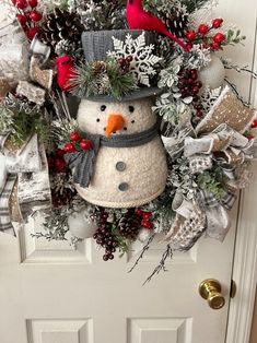 a christmas wreath with a snowman and cardinal on it