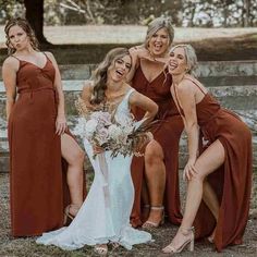 the bride and her bridesmaids pose for a photo in front of a fence