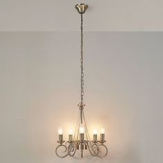 a chandelier with five lights hanging from it's sides in a room