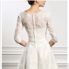 the back of a woman's wedding dress with sleeves and laces on it