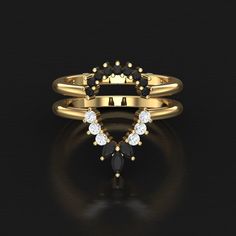 a gold ring with black and white stones on it, set in the shape of a heart