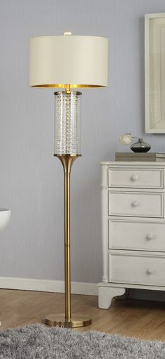 a lamp that is sitting on top of a wooden floor next to a dresser and mirror