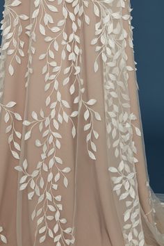 the back of a wedding dress with white flowers on it