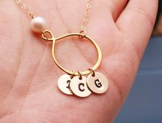 This gold pear shaped infinity necklace with initial discs consists of1. a 24k gold dipped sterling silver infinity charm connected in-line with the chain2. a birthstone bead of your choice3. one or more 14k gold filled disc charm (22ga, 3/8") stamped with an initial in your choice of font 4. a 14k gold filled chain closed with a lobster claspPackaged in a very presentable gift box (as shown)You can expect the highest stamping quality from my shop - thick gauge discs, uniformly deep impression, Gold Dangle Jewelry With Initials, Personalized Teardrop Pendant Necklace For Anniversary, Teardrop Jewelry For Anniversary And Mother's Day, Teardrop Jewelry For Mother's Day Anniversary, Personalized Teardrop Jewelry As Gift, Personalized Teardrop Jewelry Gift, Personalized Teardrop Jewelry For Mother's Day, Personalized Teardrop Pendant For Mother's Day, Personalized Teardrop Wedding Necklaces