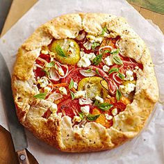 a pizza sitting on top of a piece of paper next to a knife and fork