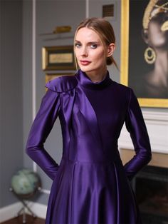 Embrace elegance and sophistication with this stunning purple long dress, designed to make you stand out at any formal event. The dress features a high neck with a delicate bow detail, adding a touch of feminine charm. The luxurious satin fabric drapes beautifully, creating a graceful silhouette. The long sleeves and modest length make it a perfect choice for a variety of occasions, from weddings to gala dinners. Pair it with your favorite heels and minimal accessories for a look that's both tim Purple Long Dress, Dress With High Neck, Modest Evening Dress, Minimal Accessories, Neck Bow, Flowing Skirt, Draped Fabric, Bow Detail, Dress Clothes For Women