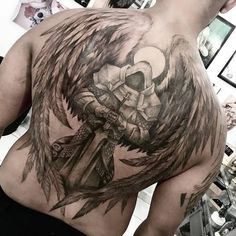 the back of a man with an angel tattoo on his upper and lower half is shown