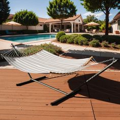 a hammock sitting on top of a wooden deck next to a swimming pool