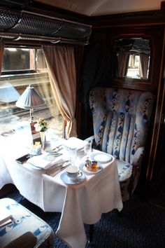 a dining car on a train with blue and white decor, including a table set for two