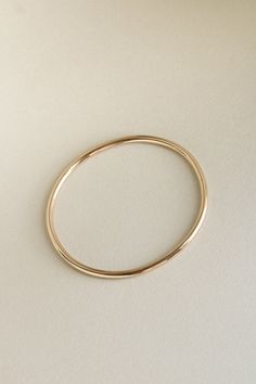 The Georgia Bangle is modern yet timeless—a minimalist bracelet featuring an organic oval shape, designed for constant wear. It is comfortable enough for sleep and sport, and strong enough to gracefully withstand decades of daily use. Each hand-soldered bracelet is shaped to mimic the contours of your forearm. Available in durable 14k gold fill, solid sterling silver, and solid 14k or 18k gold, these materials are solid (not hollow), water-resistant, and low maintenance. This bangle is truly mad Soldered Bracelet, Gold Bracelet Design, Gold Bracelet Bangle, Dainty Fine Jewelry, Two Tone Bracelet, Minimalist Bangle, Modern Gold Jewelry, Instagram Jewelry, Accesories Jewelry