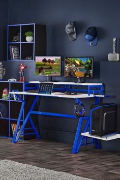 a blue desk with two monitors on top of it and some shelves in the background